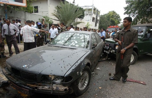 A Sri Lankan soldier stands alert beside the bomb damaged vehicle of Sri Lankan Defence Ministry Secretary Gotabaya Rajapakse after a suicide bomb attack in Colombo, 01 December 2006. A suspected Tamil suicide bomber attacked a defence ministry convoy carrying the president's brother, killing at least one soldier, police said. Gotabaye Rajapakse, secretary to the defence ministry and brother of President Mahinda Rajapakse, was unhurt after the blast in the heart of the Sri Lankan capital. AFP PHOTO/Lakruwan WANNIARACHCHI. (Photo credit should read LAKRUWAN WANNIARACHCHI/AFP/Getty Images)